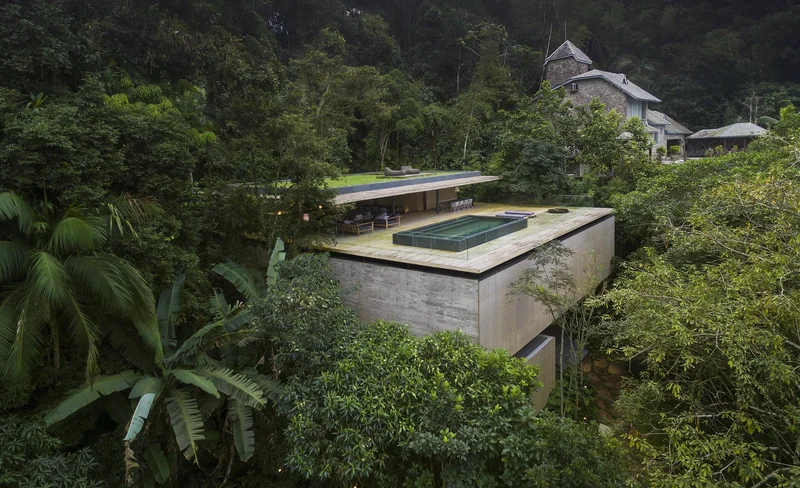 Casa da Mata moderna integrada à natureza com grandes janelas e vegetação exuberante