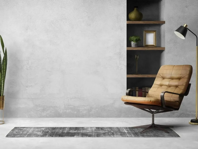 Parede de cimento queimado em um banheiro, servindo de fundo para uma bancada de madeira e cuba de apoio branca.