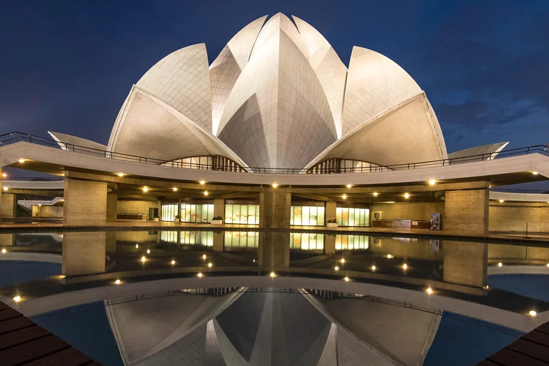 Fachada de uma casa contemporânea com linhas retas, grandes vãos de vidro e integração com a natureza.