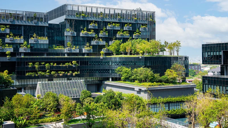 Edifício moderno com telhado verde e painéis solares, simbolizando a construção sustentável.