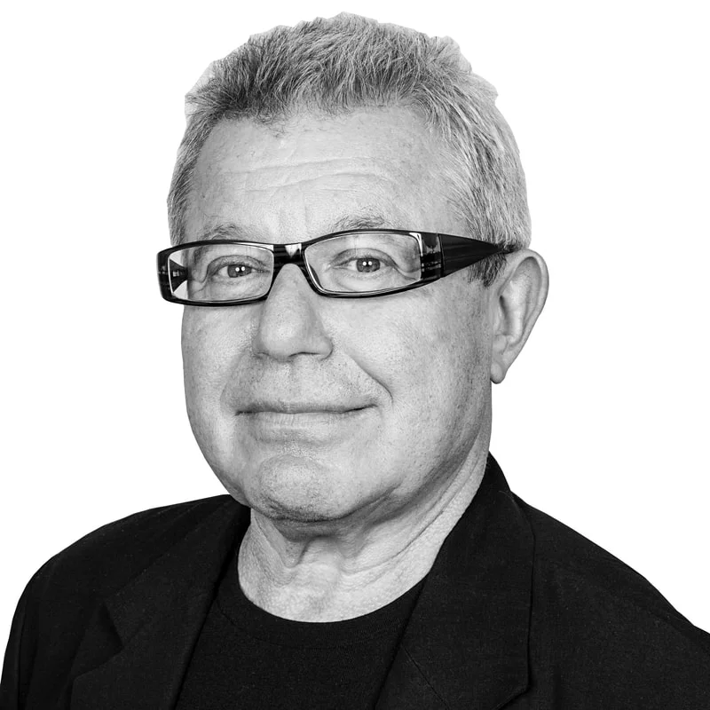 Daniel Libeskind em seu escritório, revisando maquetes e plantas arquitetônicas, com foco na complexidade de seus projetos.