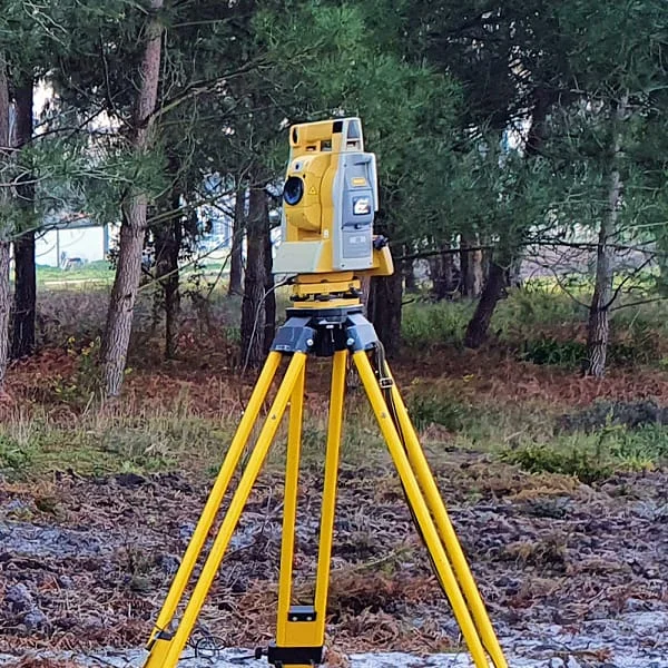 Topógrafo utilizando uma estação total para realizar um levantamento planialtimétrico