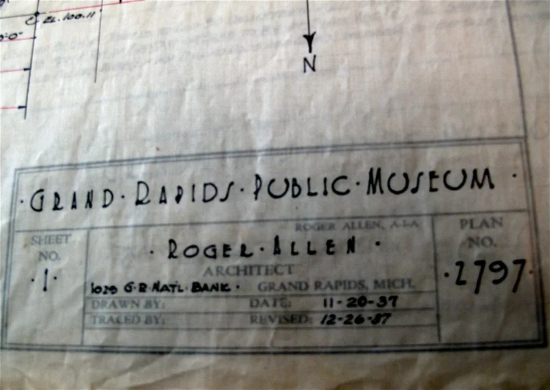 Uma mão assinando um projeto arquitetônico, simbolizando a autoria e a proteção legal.