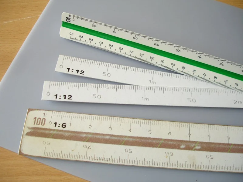 Close-up de um escalímetro mostrando as diferentes graduações das escalas 1:20 e 1:50.
