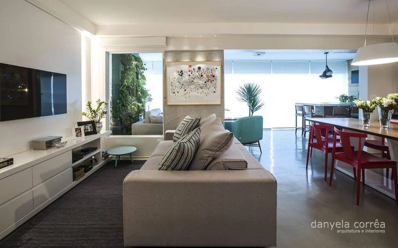 Sala de estar com piso de cimento queimado, móveis contemporâneos e decoração urbana