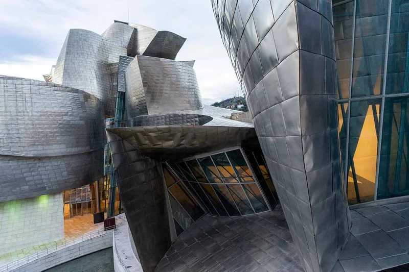 Vista aérea do Museu Guggenheim Bilbao, mostrando suas formas curvas e o rio Nervión