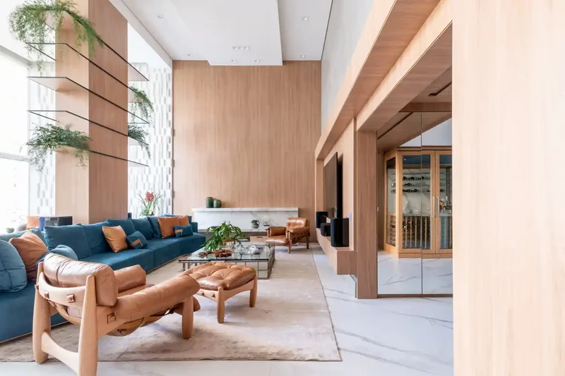 Sala de estar com pé-direito duplo e grandes janelas de vidro.