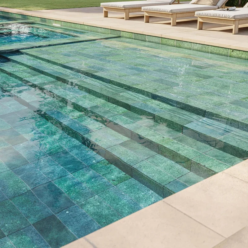 Piscina com borda infinita revestida com porcelanato que imita pedra Hijau.