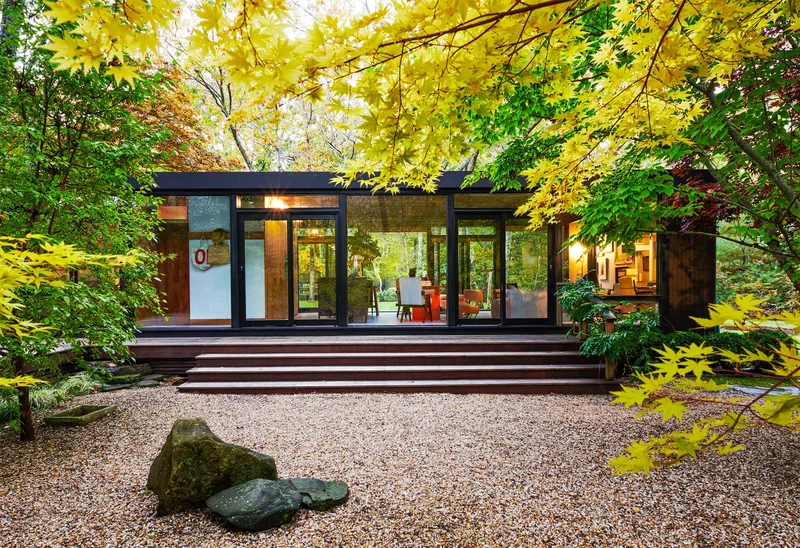 Arquiteta analisando projetos de casas em uma mesa de trabalho.