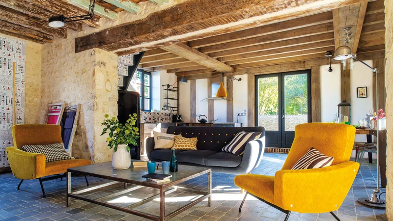 Sala de estar com decoração inspirada nos anos 70, com sofá de veludo laranja e papel de parede geométrico.