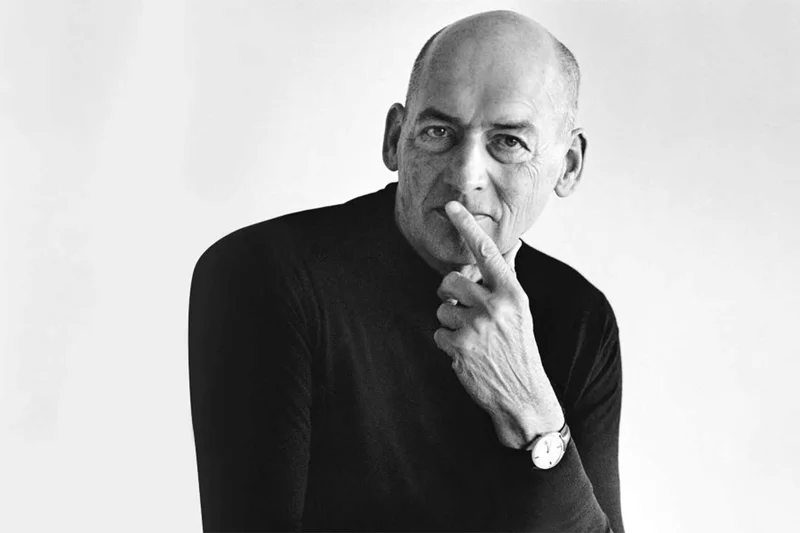 Rem Koolhaas em uma palestra, com um fundo de slides de projetos urbanos complexos.