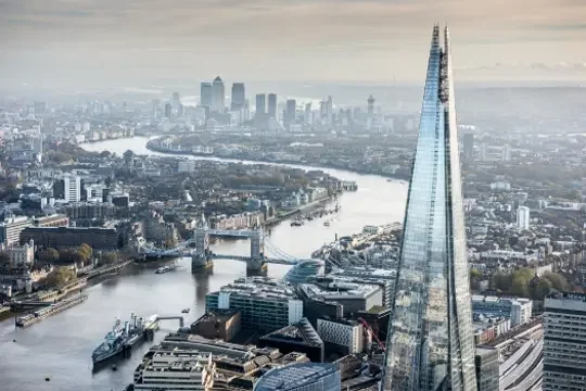 Vista externa do The Shard em Londres, com sua forma piramidal de vidro refletindo o céu.